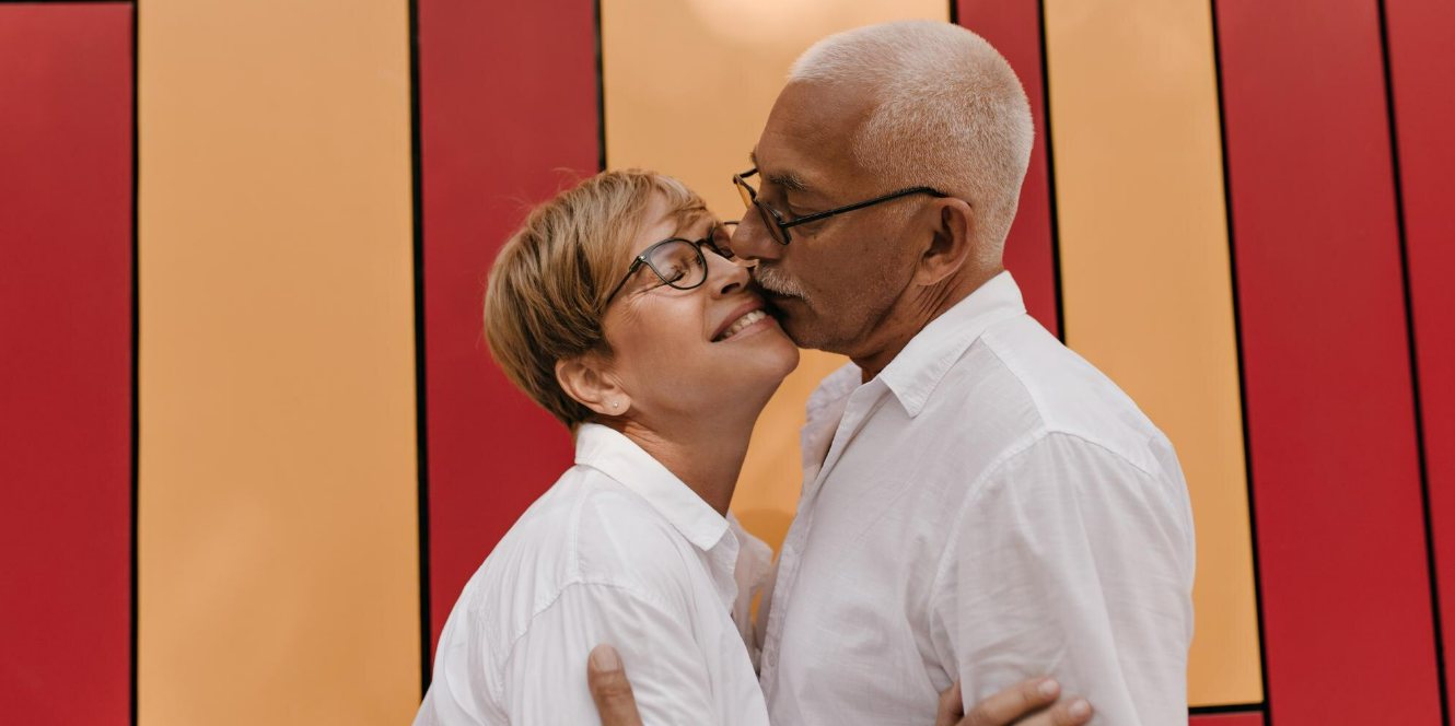 Senior couple standing closely in a warm setting