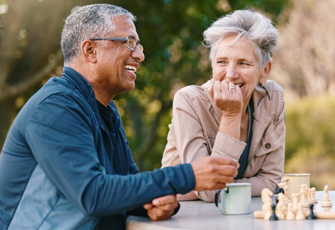 Older couple in conversation at an outdoor table
